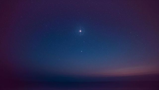 Bright Star Shining Over Ocean at Dusk with Scattered Stars