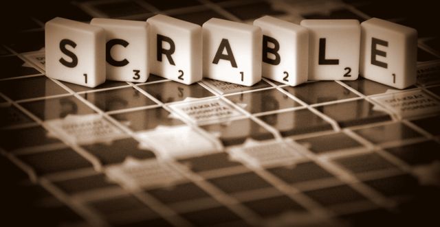 Sepia-toned image displaying Scrabble tiles arranged on a game board. Perfect for use in nostalgic, vintage, or family-themed marketing materials. Ideal for illustrating articles on board games, family fun nights, or as a visual aid in educational content about word games.