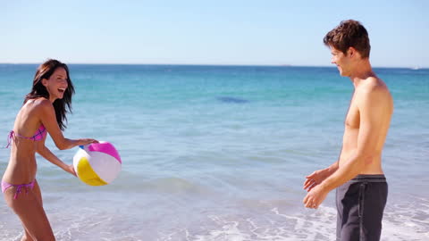Couple Enjoying Beach Day with Colorful Beach Ball