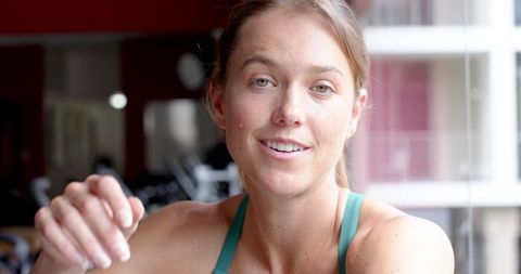 Caucasian Woman in Gym Resting After Intense Workout, Exhibiting Fitness and Determination