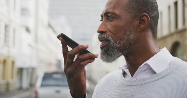 Mature man using smartphone voice control on city street - Download Free Stock Images Pikwizard.com