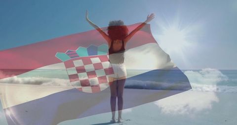 Woman celebrating freedom on beach with croatian flag