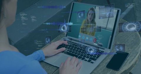 Man joining remote video meeting on laptop with digital HUD overlays and smartphone nearby