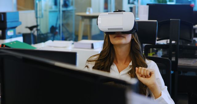 Woman in a modern office using a virtual reality headset, demonstrating the integration of cutting-edge technology in a work environment. This imagery can be used for articles and advertisements on innovation in the workplace, tech advancements, professional training, and remote work.
