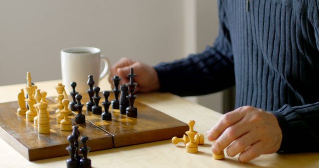 Person deeply engaged in a game of chess with a cup of coffee on the table at home. Suitable for depicting themes such as concentration, strategy, leisure activities, and moments of relaxation.