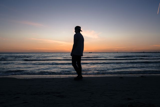 Silhouette of Man Walking on Beach at Sunset - Download Free Stock Photos Pikwizard.com