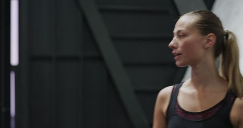 Athletic Woman in Modern Fitness Studio with Subdued Lighting