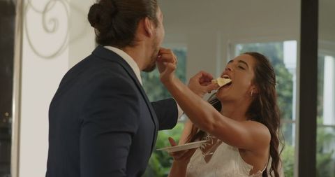 Bride and Groom Enjoy Tasting During Wedding Celebration Indoors