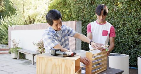 Father and Son Collaborating on Crate Assembly Outdoors