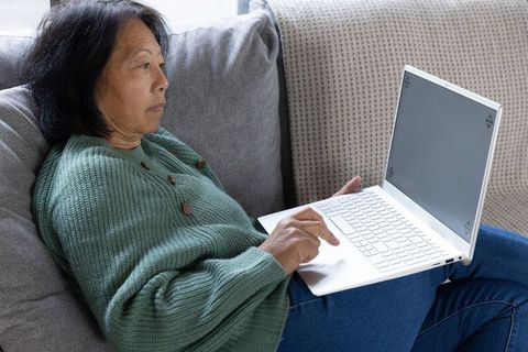 Senior Woman Relaxing with Laptop at Home Living Room