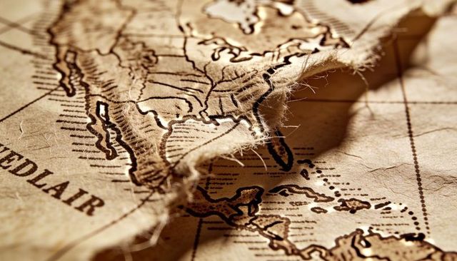 Revealing frayed edge of vintage parchment map showing north america coastlines in sepia