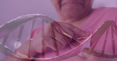 Mature woman touching wearable chest sensor with dna overlay for health monitoring and genetics