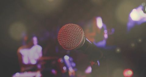 Microphone in spotlights with band in club ambience