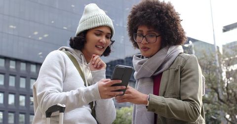 Two Friends Checking Smartphone During Urban Commute With Luggage