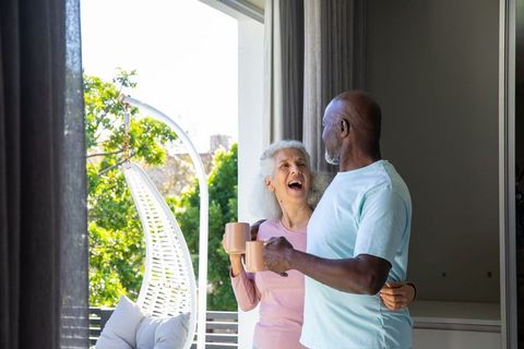 Senior Couple Enjoying Leisure Moment on Sunny Balcony