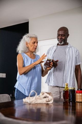Senior Couple Checking Home-Made Jars in Kitchen