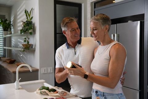 Senior couple reading ingredient label together in modern kitchen