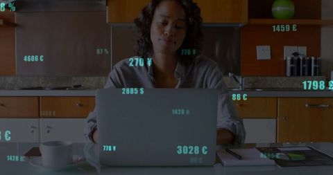 Woman Reviewing Financial Data at Home with Laptop in Kitchen