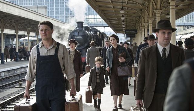 Mother Leading Son Through Busy 1940s Train Platform With Steam Locomotive