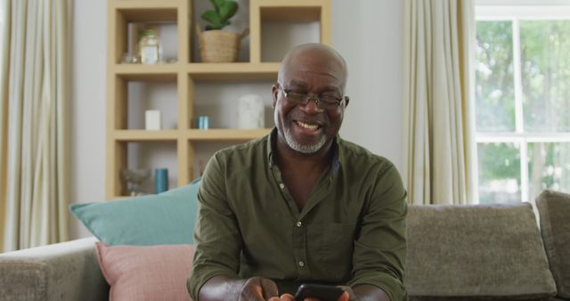 Smiling Senior Man Using Smartphone in Modern Living Room - Download Free Stock Images Pikwizard.com