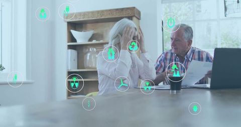 Senior Couple Managing Finances Amid Eco-Friendly Icons at Home