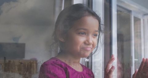 Joyful Biracial Girl Gazing Through Window Over Cityscape
