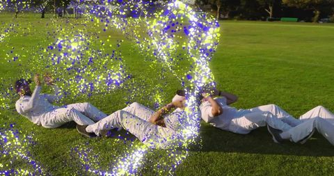 Four Athletes Performing Core Workout on Green Field with Vibrant Particle Overlay