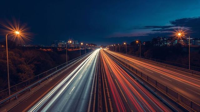Streaming light trails racing along multi-lane highway at night with glowing streetlights