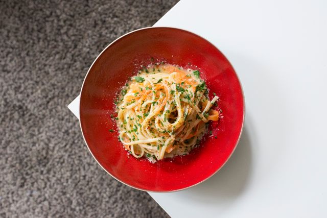 Depicting a mouth-watering plate of spaghetti carbonara sprinkled with parmesan cheese, fresh herbs, and garnished with breadcrumbs. Perfect for use in food blogs, recipes, restaurant menus, and culinary advertisements.