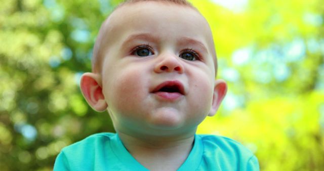 Close-up of Baby in Light Blue Shirt Outdoors on a Sunny Day - Download Free Stock Images Pikwizard.com