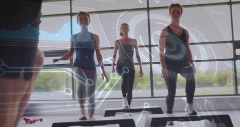 Instructor leading group step aerobics class, adults stepping on platforms in bright gym