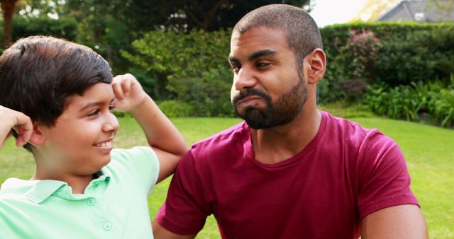 Father Playfully Reacting to Son's Antics in Garden - Download Free Stock Images Pikwizard.com