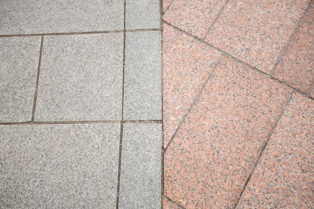 Contrasting paving stone patterns on a sidewalk, showcasing different textures and colors. Ideal for use in urban design projects, architectural presentations, construction materials catalogs, and cityscape illustrations.