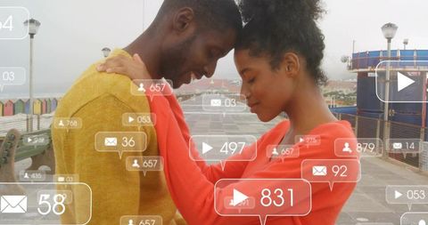 Couple pressing foreheads on boardwalk with social media notification overlay