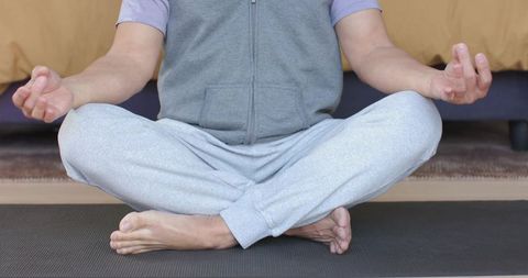 Asian Mature Man Meditating in Bedroom for Mindfulness and Relaxation