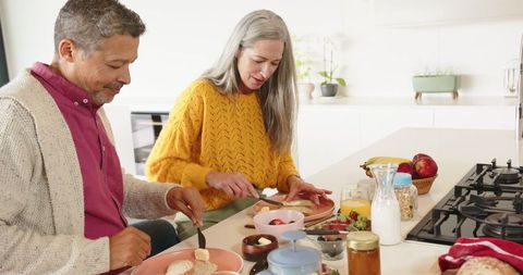 Senior Couple Preparing Breakfast Together at Modern Kitchen Island