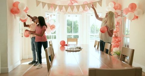 Friends Decorating House with Balloons for Celebration