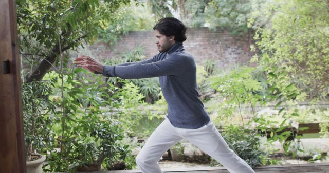 Man Practicing Tai Chi in Garden Amidst Lush Greenery - Download Free Stock Images Pikwizard.com