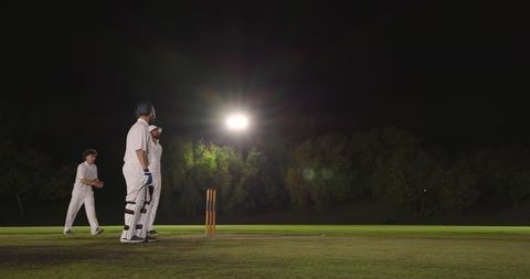 Indian batsman standing at crease during night cricket match under floodlights