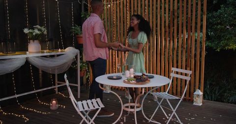 Romantic Evening Outdoors with Diverse Couple under String Lights