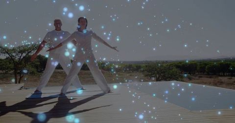 Couple practicing synchronized stretching on outdoor deck by pool