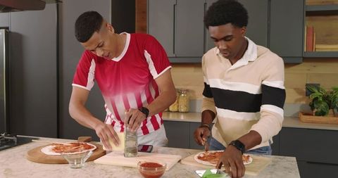 Diverse Friends Enjoying Homemade Pizza Preparation in Kitchen