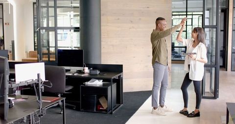 Business Colleagues High-Fiving in Modern Office Setting
