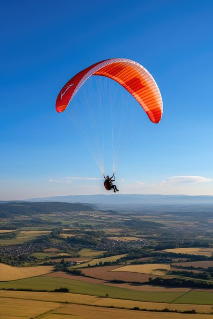Paraglider drifting over countryside landscape with blue sky, created using generative ai technology. Paragliding, sports, flying and freedom concept digitally generated image.
