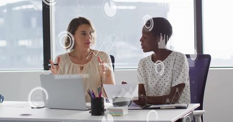 Diverse Female Colleagues Analyzing Digital Data in Modern Office