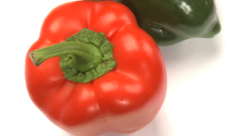 Fresh Red and Green Bell Peppers Displayed on White Background