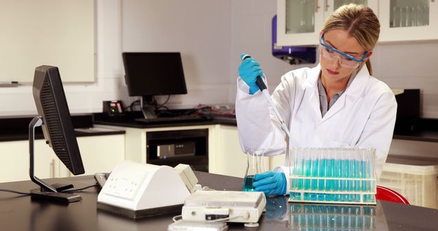 Female scientist working diligently in laboratory, conducting research using pipette and test tubes. Ideal for illustrating scientific research, medical breakthroughs, laboratory environments, chemistry studies, and women's involvement in STEM fields.