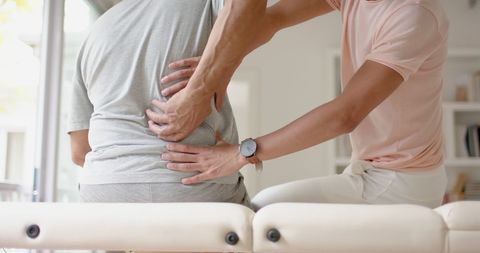 Therapist Massaging Senior Male Client for Muscle Relief