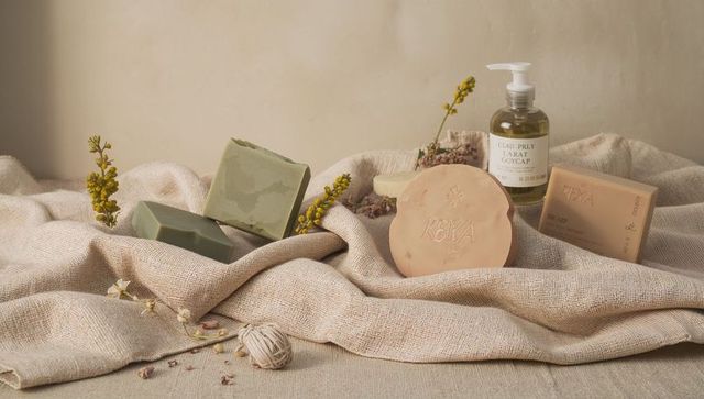 Handcrafted soap collection on textured linen with natural packaging and botanicals