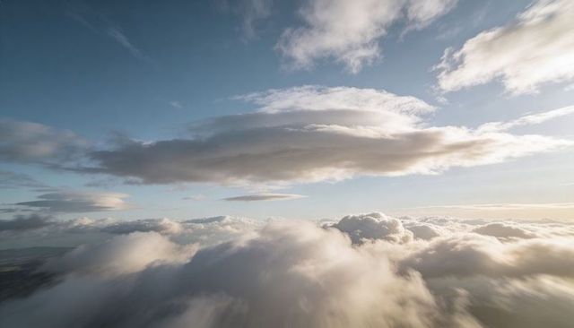 Sunlit Layered Clouds and Fluffy Cumulus Over High-Altitude Blue Sky
